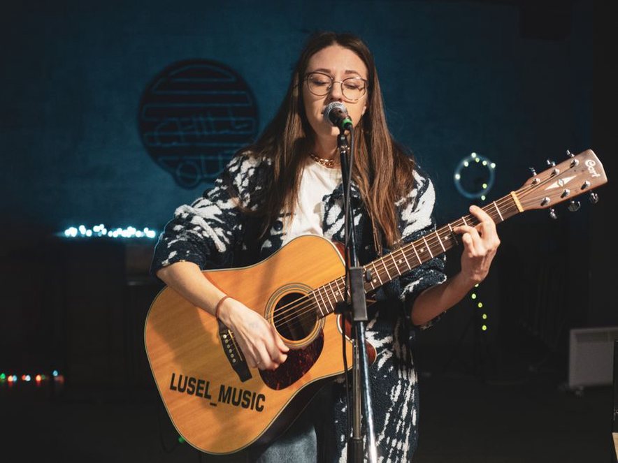 cantautore italiano sul palco con chitarra