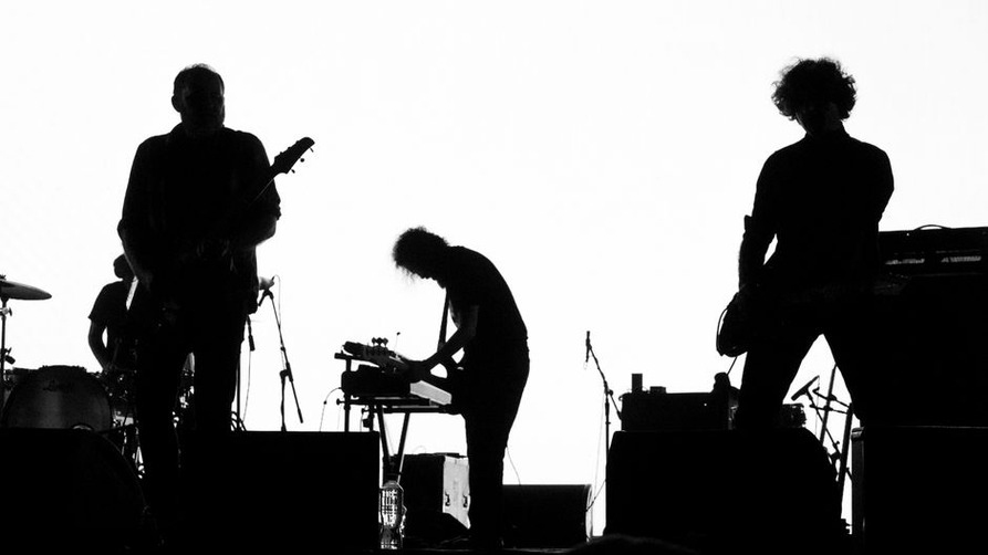 Un gruppo rock suona dal vivo tra tastiere e batteria