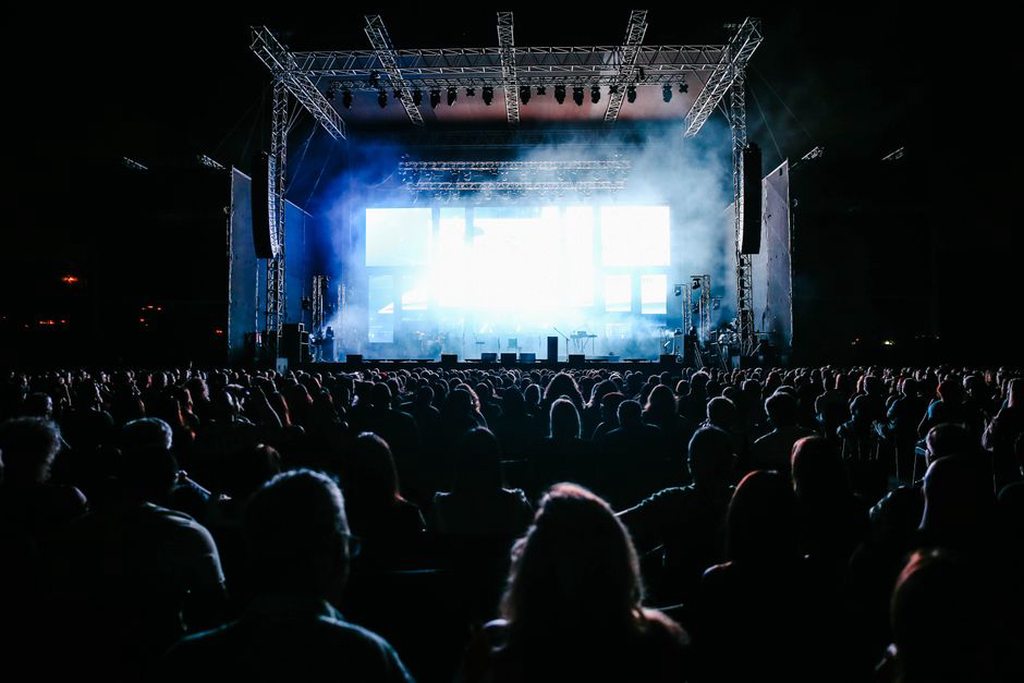 Folla raccolta davanti al palco di un concerto benefico