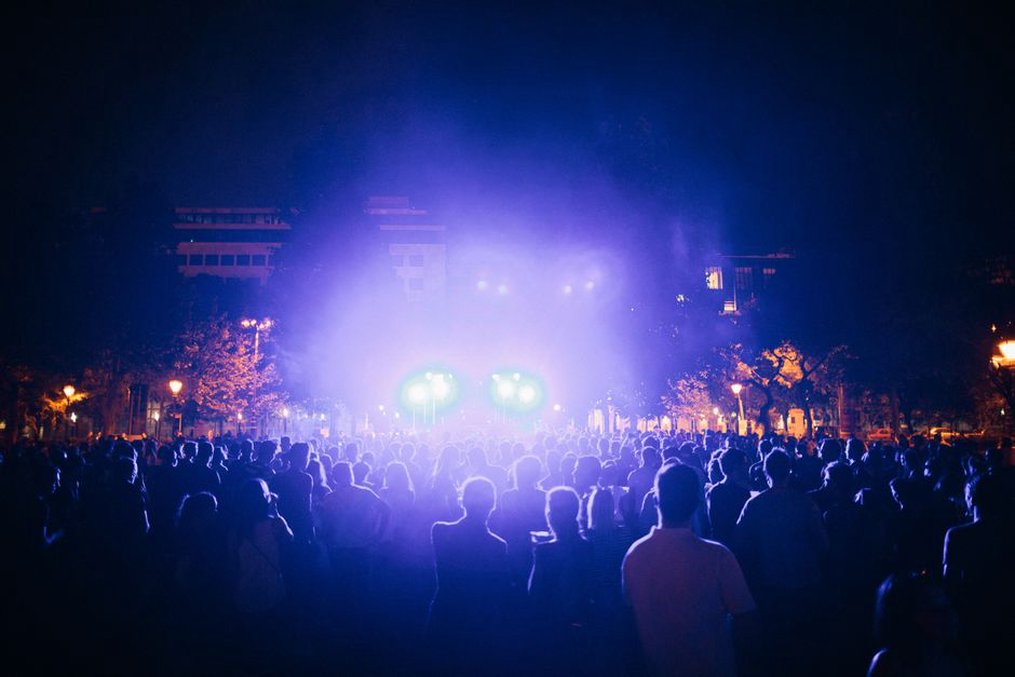 Il pubblico si raccoglie sotto le luci del palco