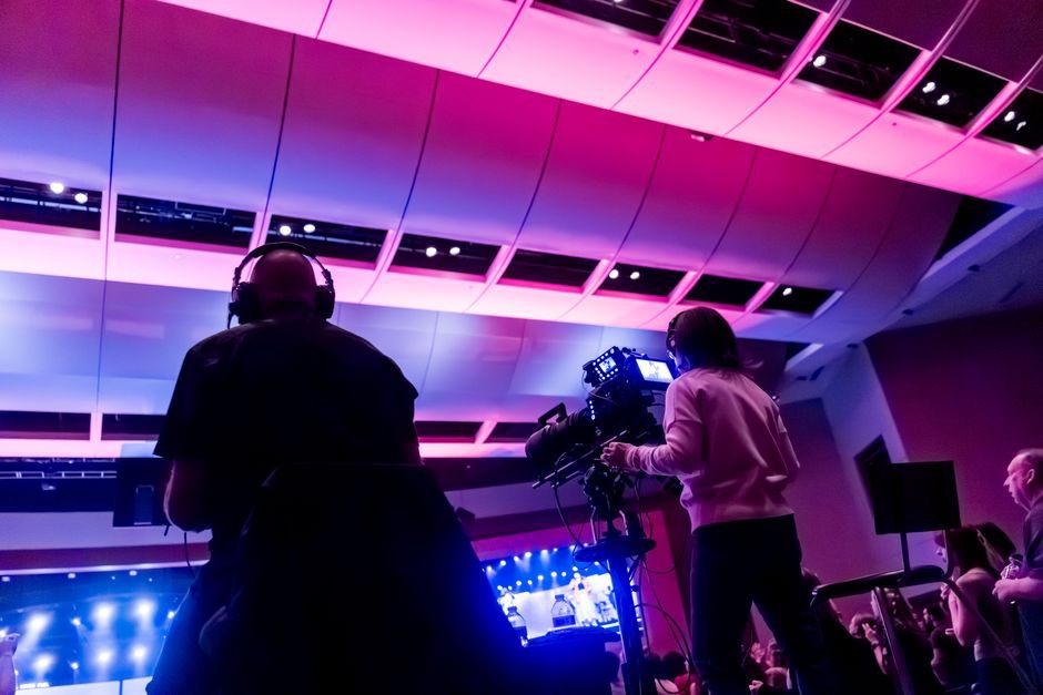 Telecamere puntate sul palco davanti a una grande folla