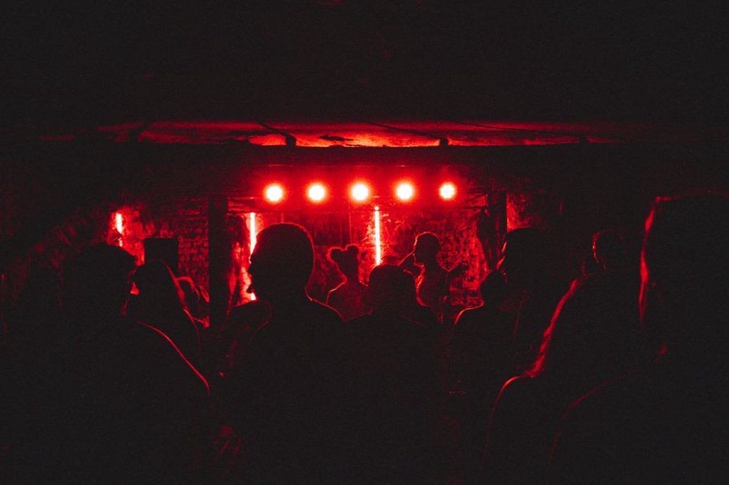 Pubblico raccolto vicino al palco di un piccolo club