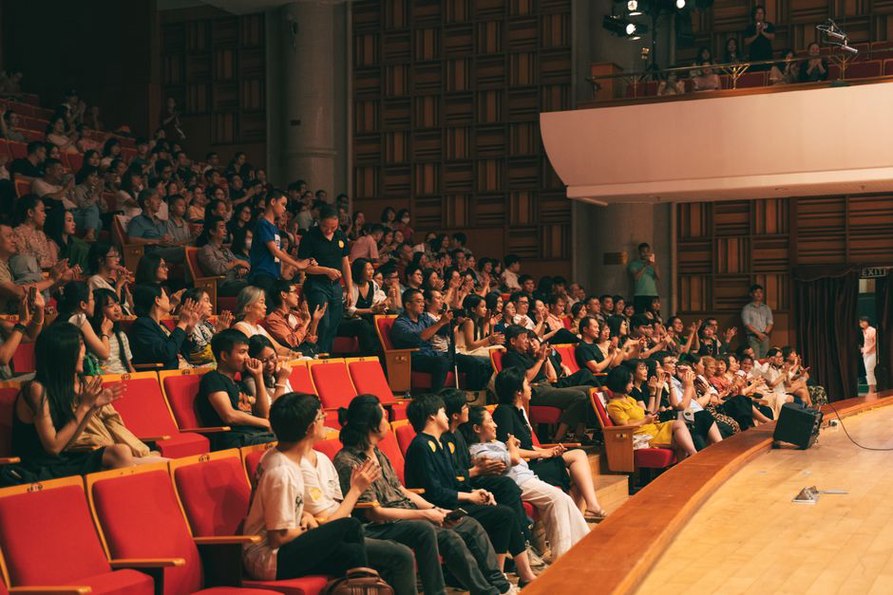 Il pubblico ascolta in un piccolo locale