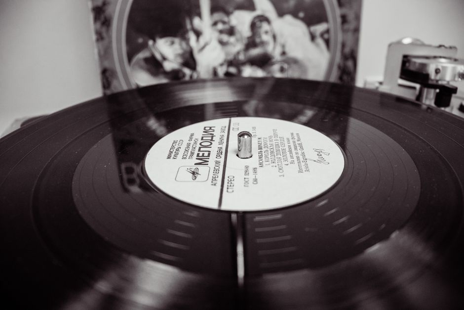 Un disco sul giradischi accanto alla copertina aperta